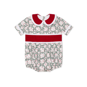 Grace Bubble in Regent Wreaths holiday print with red velvet sash and Peter Pan collar, finished with crisp white pleated trim for baby and toddler girls.