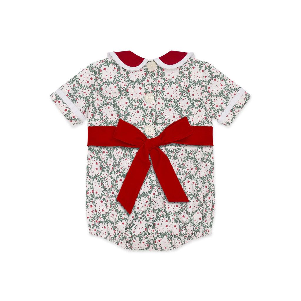 Grace Bubble in Regent Wreaths holiday print with red velvet sash and Peter Pan collar, finished with crisp white pleated trim for baby and toddler girls.
