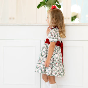 Side view of Short Sleeve Grace Dress in Regent Wreaths with red velvet Peter Pan collar, sash, puff sleeves, and full skirt
