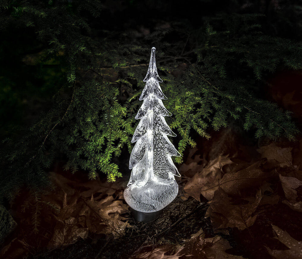 Front view of Silver Leaf Evergreen glass tree showcasing silver-infused textured finish lit on dark forest-floor