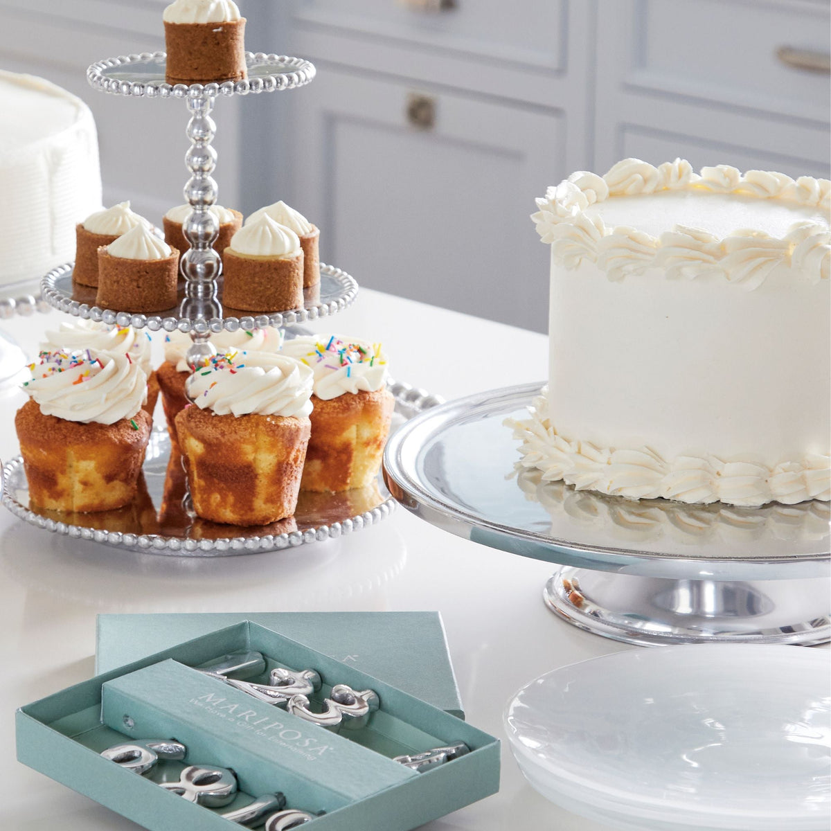 Front view of Signature Cake Stand showcasing beaded tiers with cakes on a white dessert table