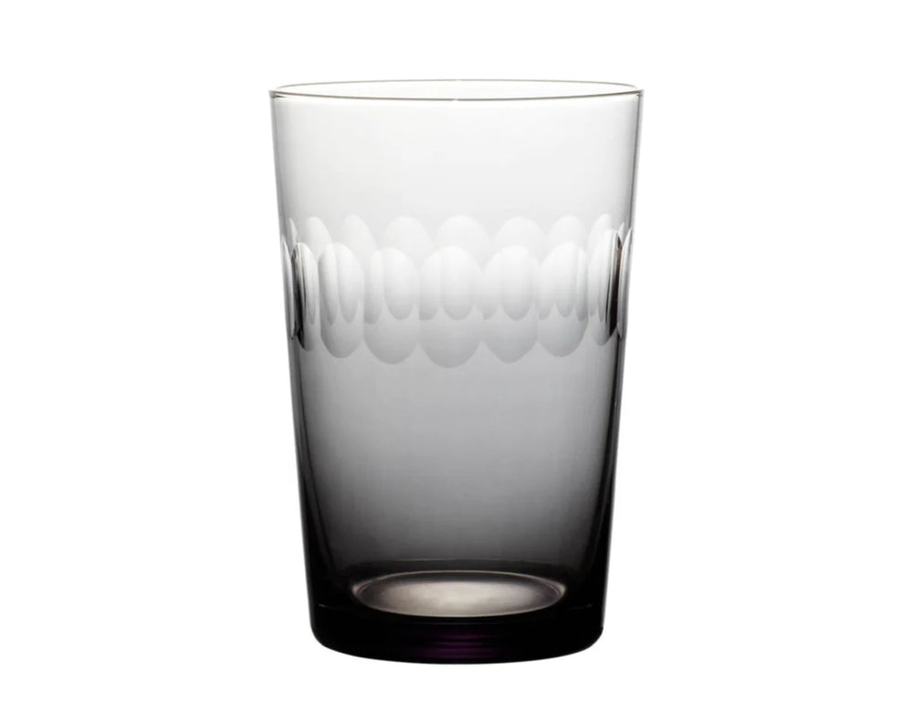 Front view of smoky hand-engraved glass tumbler showcasing a band of connecting spheres on a white background
