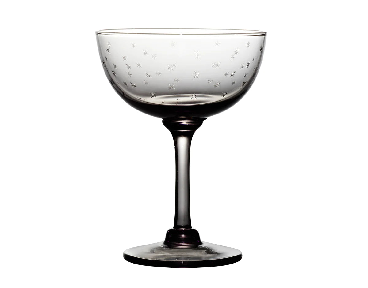 Front view of a smoky champagne saucer showcasing hand-engraved star design on a white background