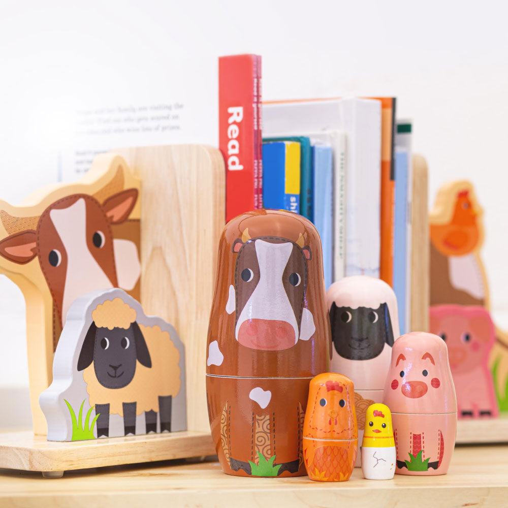 Front view of Farm Animal Russian Dolls showcasing colorful nesting farm animal designs with a bookshelf background