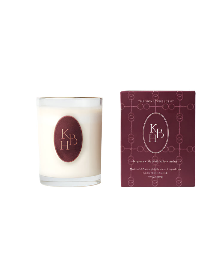 Front view of Signature Scent 10 oz candle in clear glass with burgundy KBH label beside matching burgundy box on white background