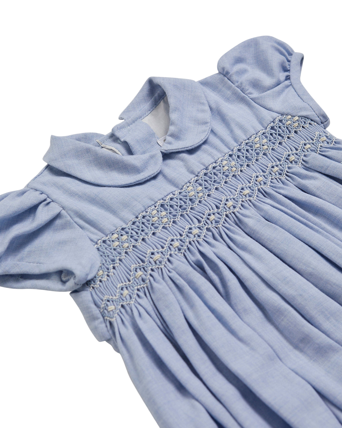 Light blue dress with smocked details on a white background