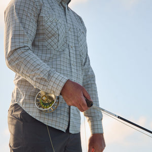 Someone in a Tom Beckbe Tidewater Shirt holds a rod, enjoying the clear sky.