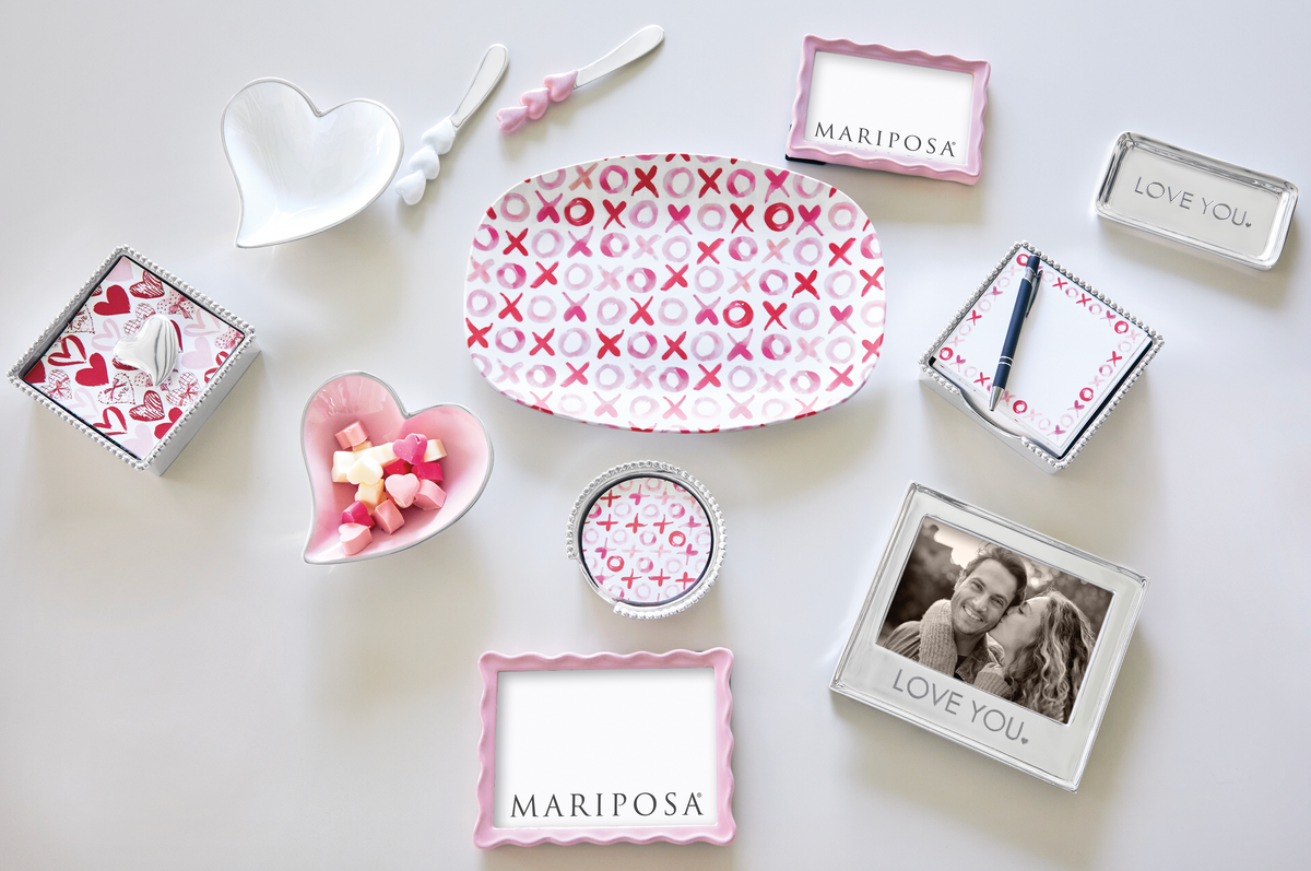 Mariposa pink and silver tabletop pieces with small pink heart bowl, XOXO platter, and frames on a pale gray background