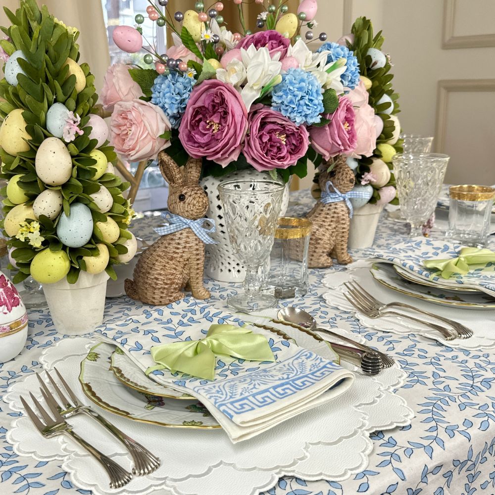 Easter-themed table setting with floral arrangements, eggs, and decorative elements.