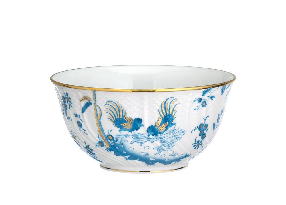 Three-quarter view of Oro Di Doccia porcelain bowl showcasing blue rooster and floral pattern with gold rim on white background