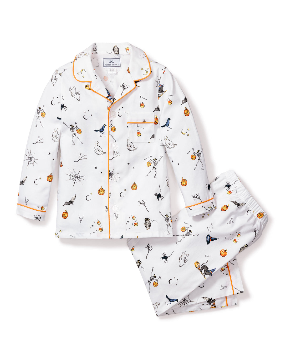 Flat lay of children’s Trick or Treat pajama set showcasing Halloween print and orange contrast piping on white background
