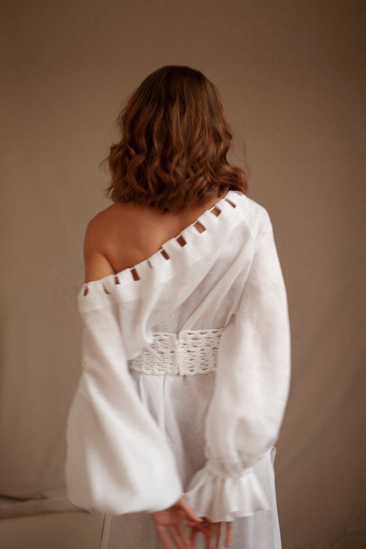 Rear view of the Jazmin Dress showcasing its off-the-shoulder neckline and flowing linen fabric against a neutral background