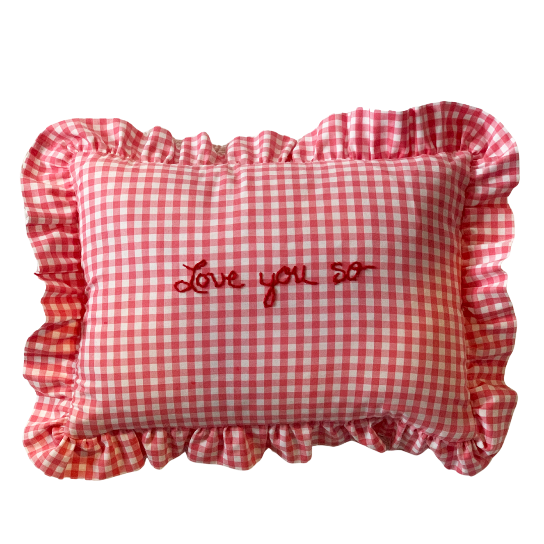 Front view of Love You So rectangle ruffle pillow in pink gingham with ruffled trim and red embroidered Love you so text