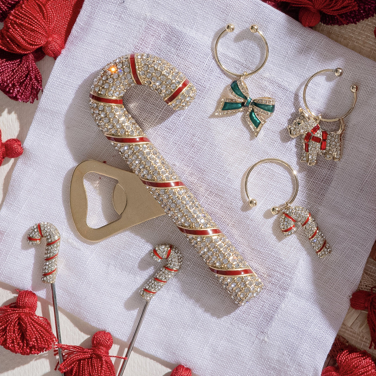 Overhead view of Candy Cane Bottle Opener showcasing jeweled detailing and red stripes on a white linen napkin