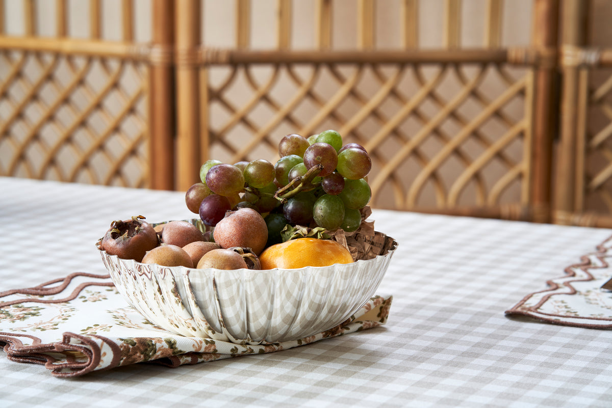 Front view of Marguerite Bowl showcasing molded and hammered sterling silver with fruit on a table