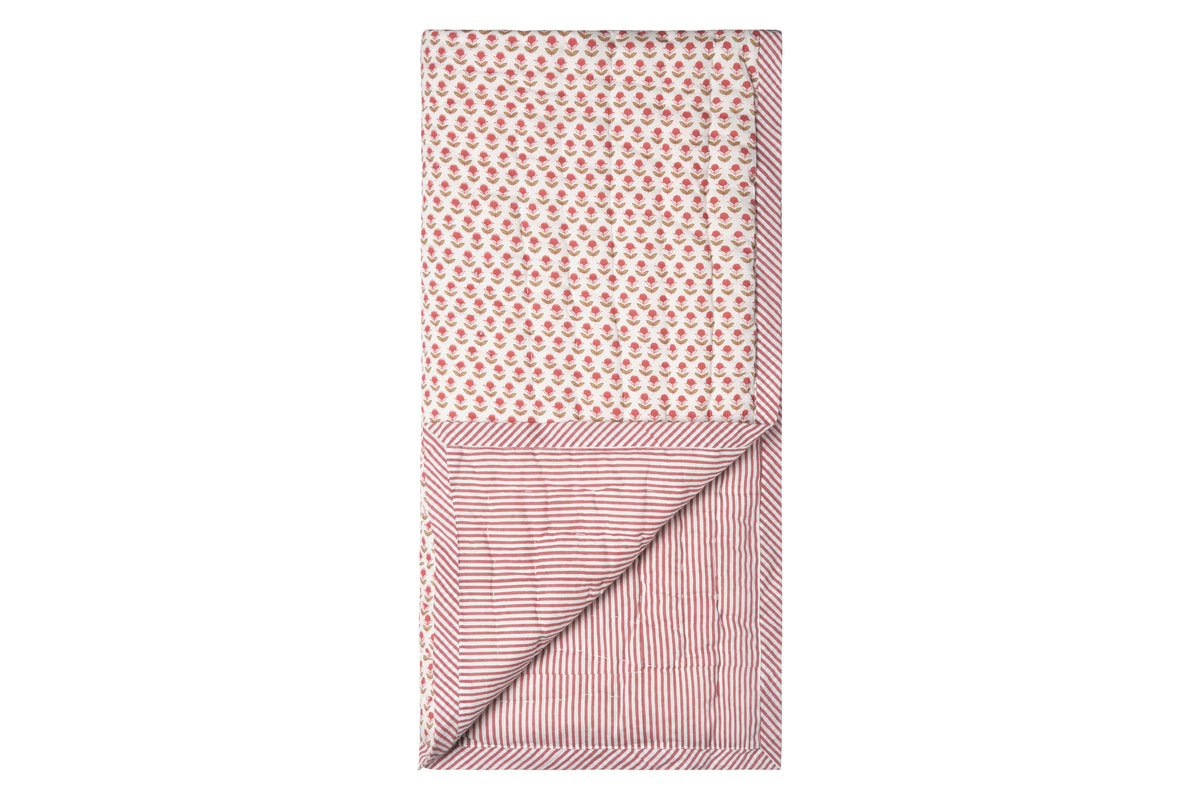 Top-down view of Pippa baby quilt showing muted red poppy print on one side and red-striped reverse on white background
