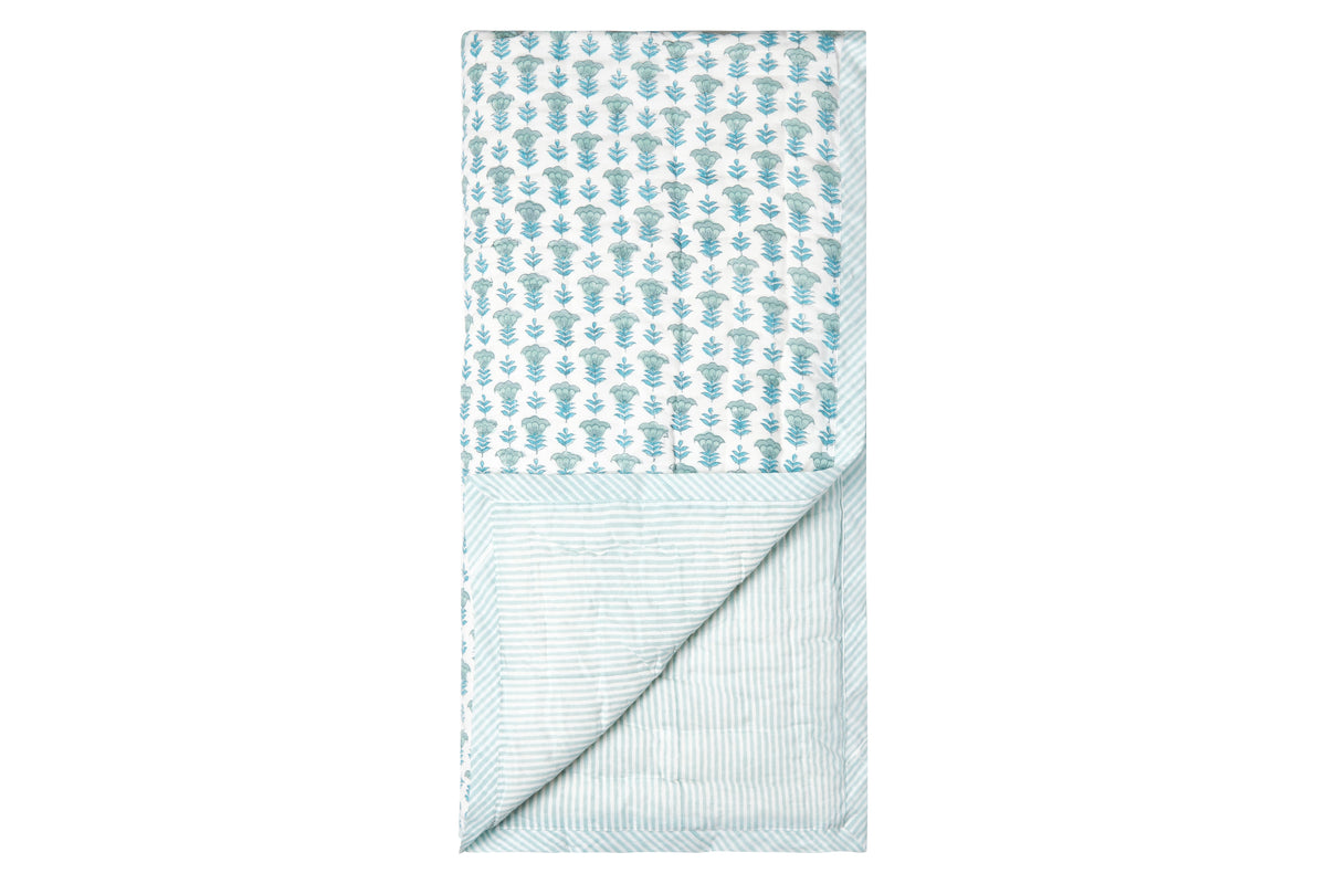 Top-down view of The Charlie Baby Quilt showing powder and baby blue floral block print with striped reverse on white background