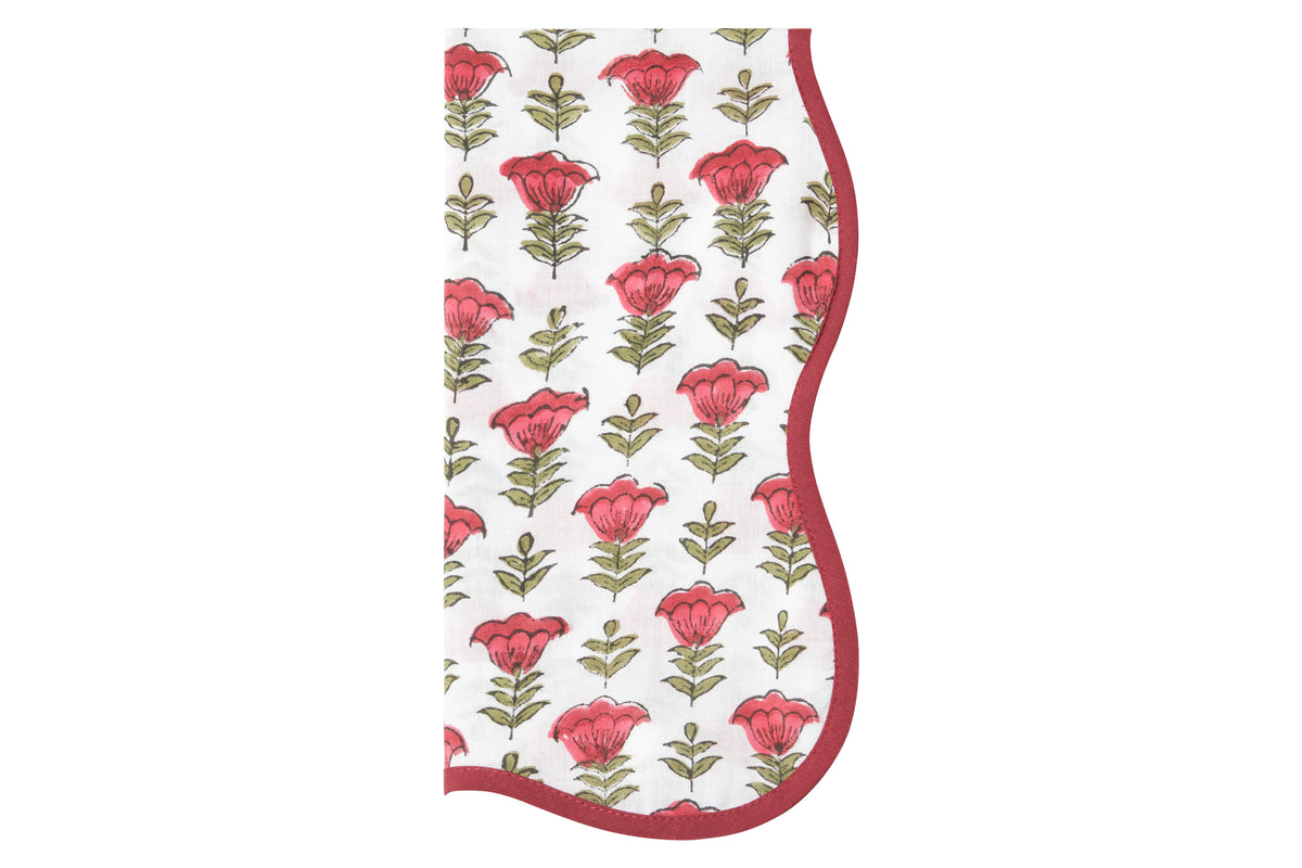 Close-up view of The Palma Napkin showcasing bold red flowers and green and pink hues on a white background