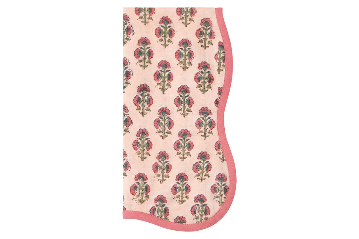 Top-down view of Beatrice napkin showcasing pink floral block-print and scalloped pink trim on white background