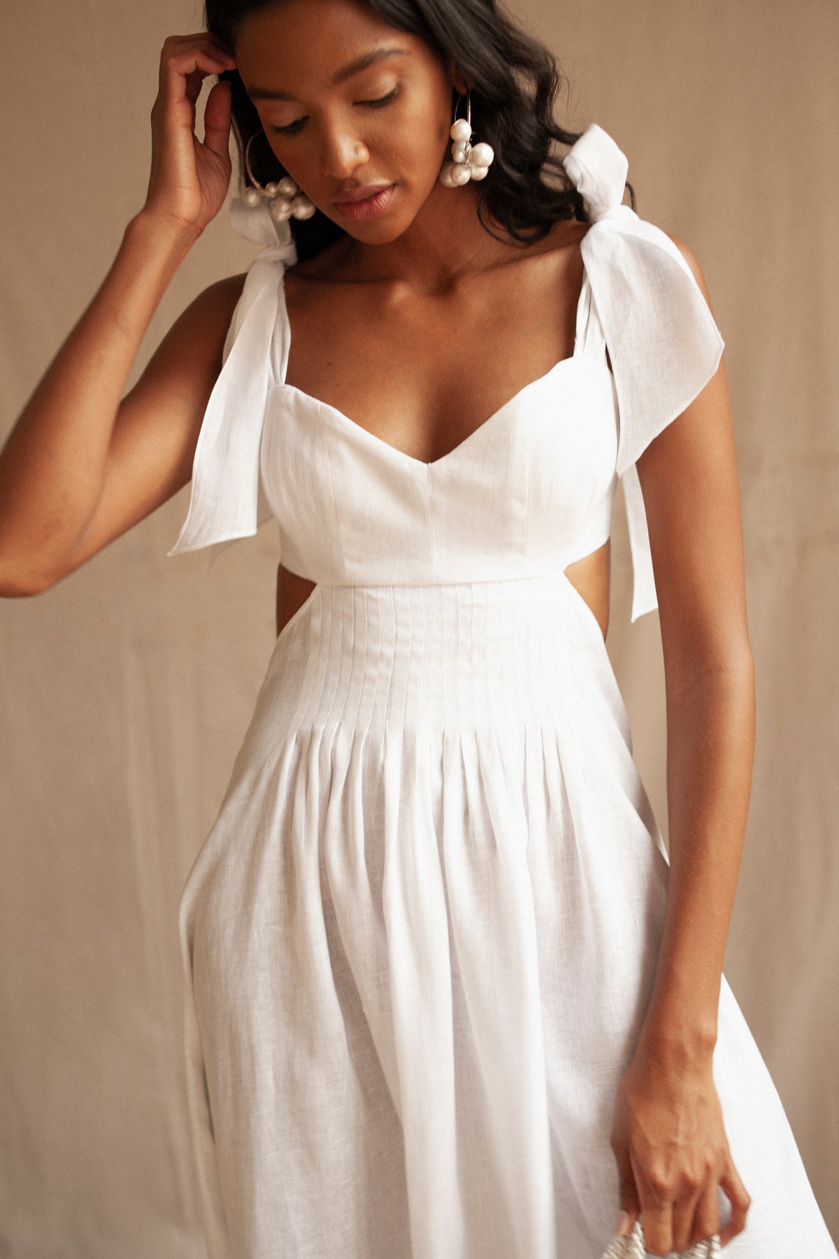 Front view of the white Margarita Dress showcasing its draped top and heart-shaped neckline with a beige background