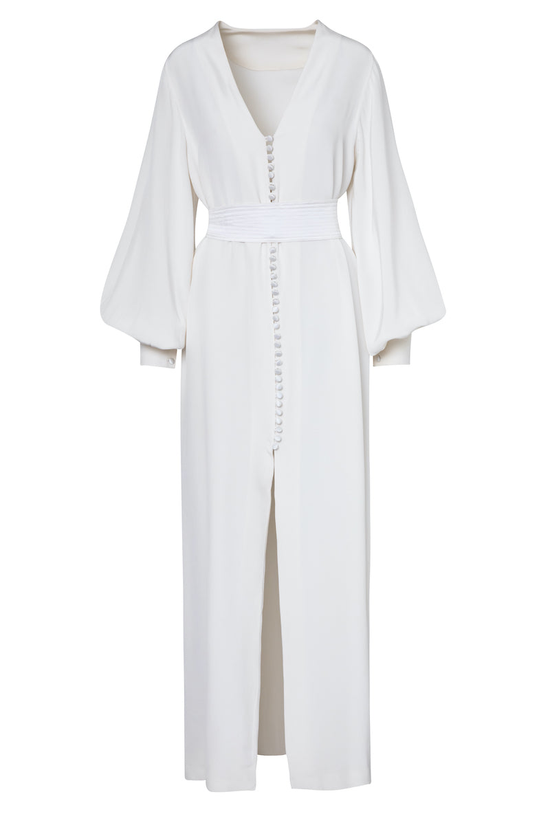 Front view of Afrodite dress showcasing deep V-neck, covered button front, pleated waist, long balloon sleeves and center slit on white background