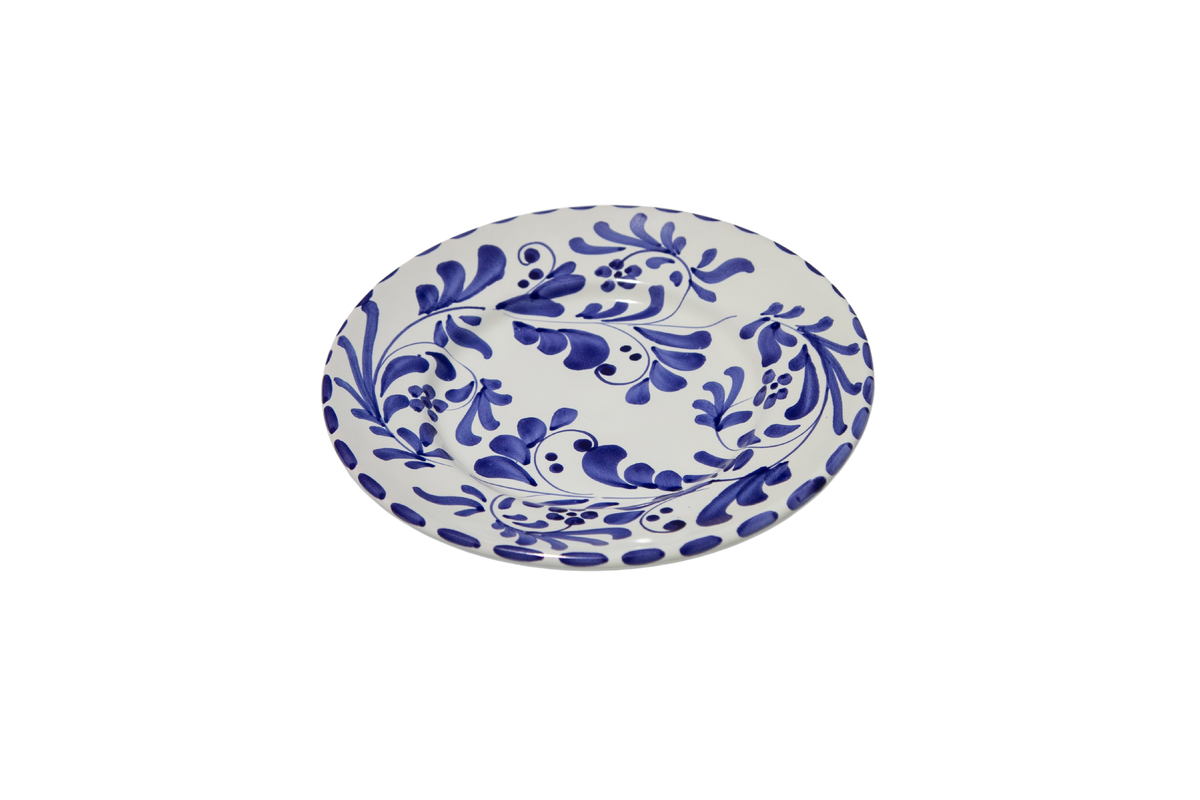 Angled view of Salad and Dessert Plate in Azul Classico showcasing blue leafy impressions on white ceramic with a black background