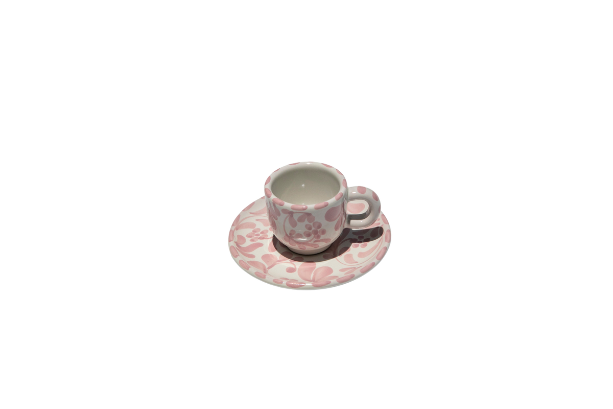 Front view of Espresso Cup with Saucer in Rosa showcasing swirling leafy impressions with a black background
