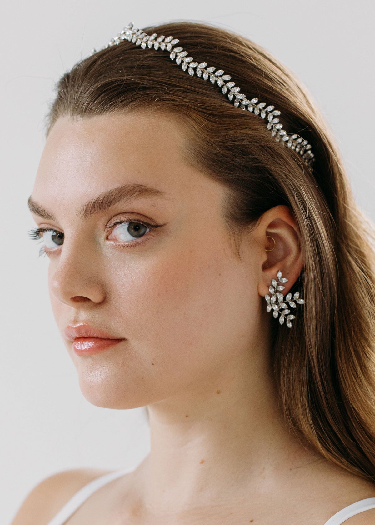Three-quarter view of Deilacte Vine Tiara headband showcasing crystal leaf motif worn by model against light background