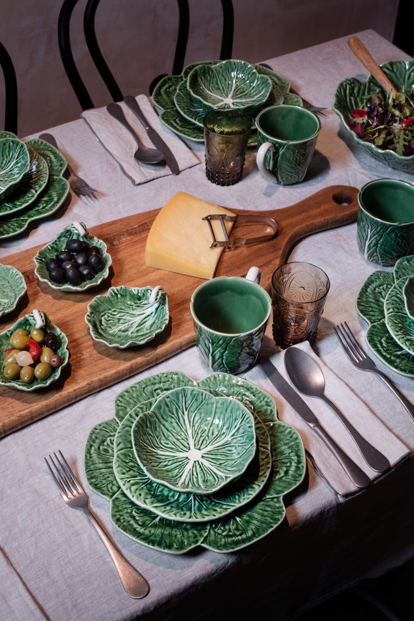 Front view of Cabbage Bowl 12 oz set of 4 showing embossed cabbage-leaf texture and glossy green glaze on linen table