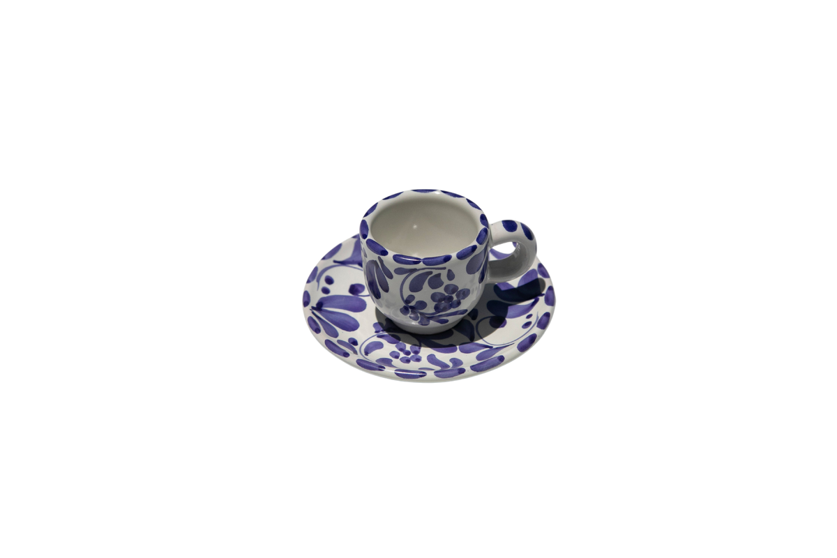 Front view of Espresso Cup with Saucer in Azul Classico showcasing swirling leafy impressions with a black background