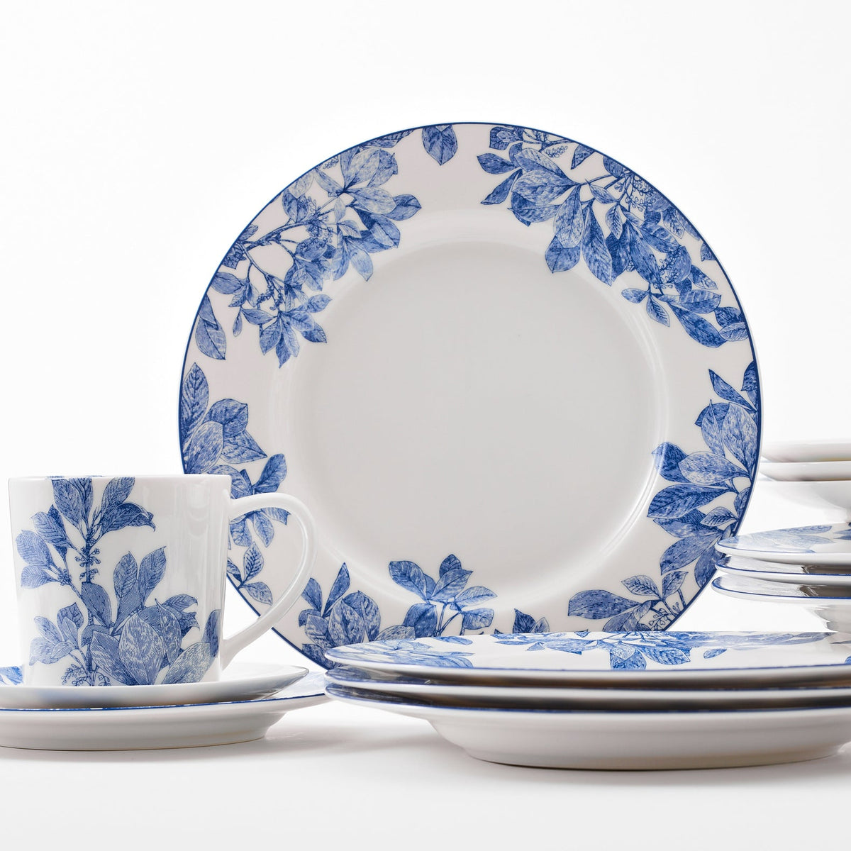 Front view of Arbor Table for 4 showcasing blue leafy branch pattern on creamy white porcelain with white background