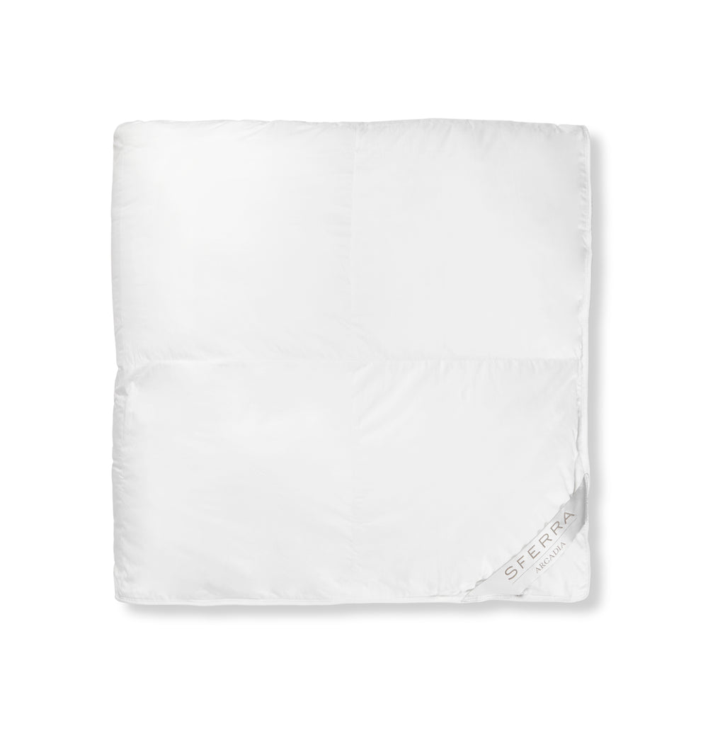 Top view of Arcadia duvet by Sferra showcasing box-stitched baffle construction and white cotton sateen finish on white background