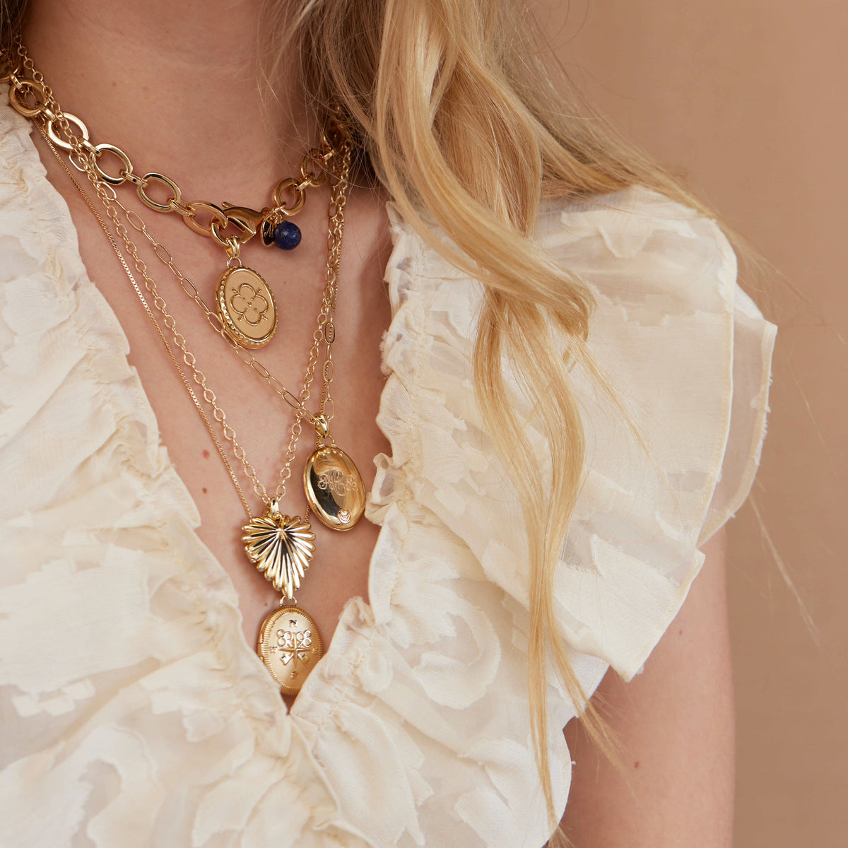 Front view of Forever JW Original Locket Necklace showcasing its oval sterling silver pendant dipped in 14k gold among layered necklaces