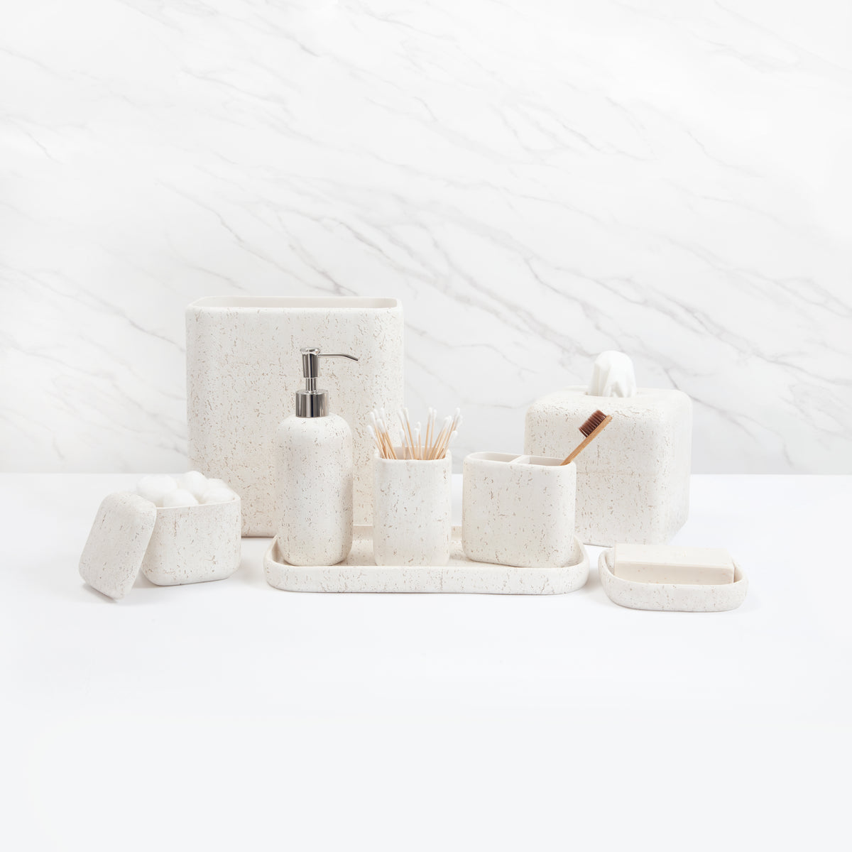 Front view of Aman tray in ivory showing speckled resin finish with matching bath accessories on marble background