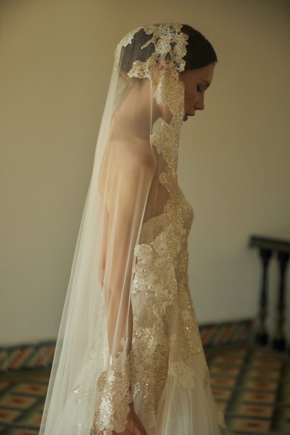Side view of Amaranta veil showcasing mid-length tulle and hand-embroidered floral appliqués against a neutral interior
