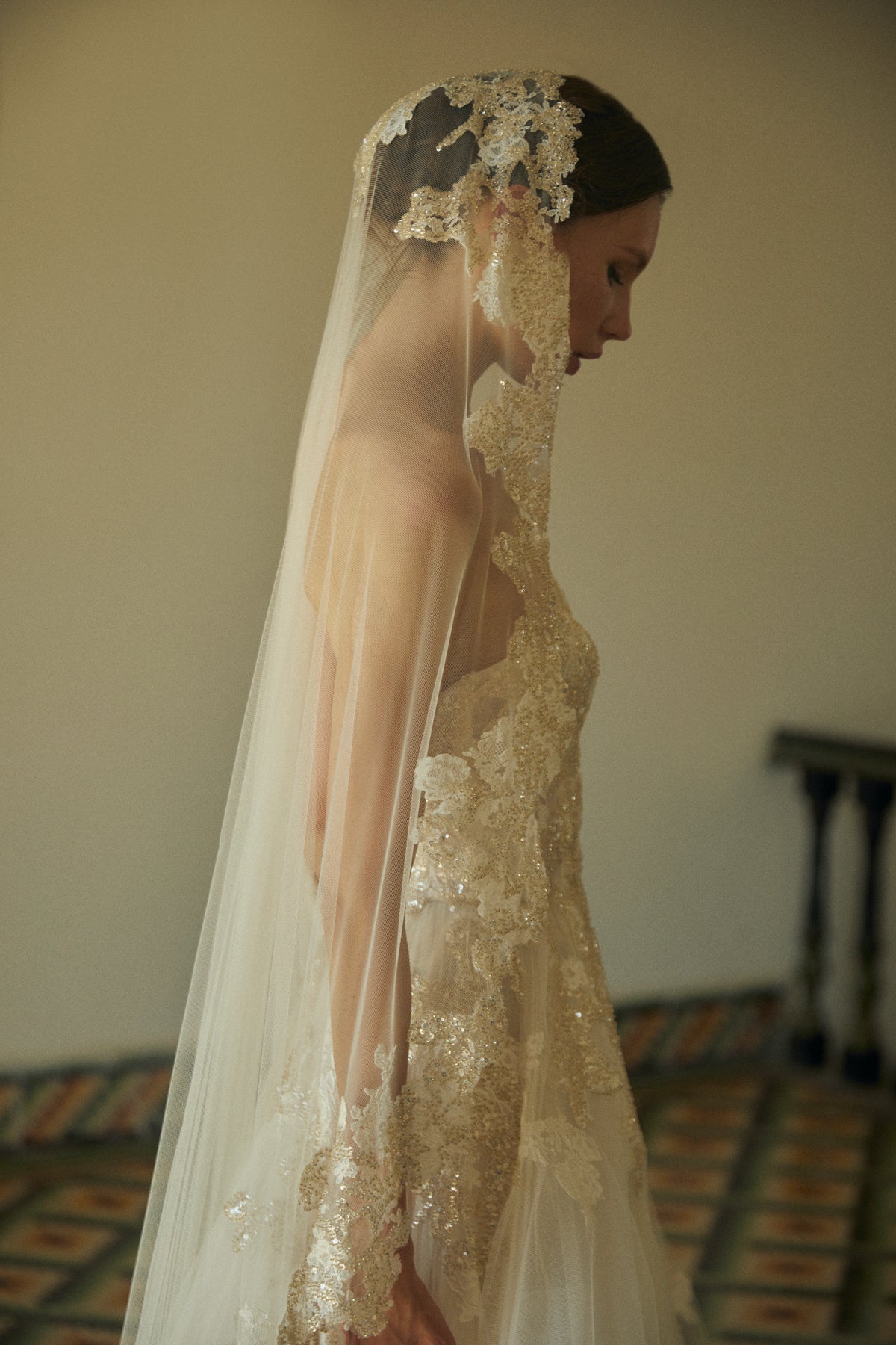 Side view of Amaranta veil showcasing mid-length tulle and hand-embroidered floral appliqués against a neutral interior