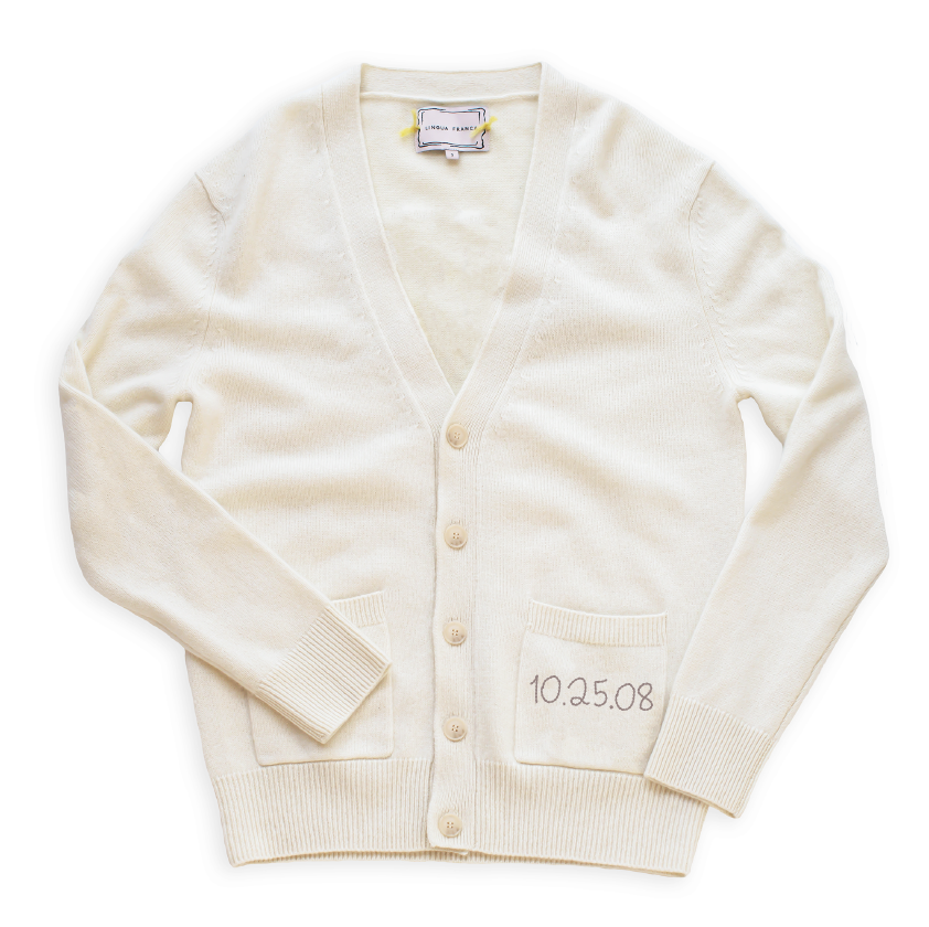 Flat lay of Anniversary oversized cardigan with V-neck button front, front pockets and embroidered date 10.25.08 on white background