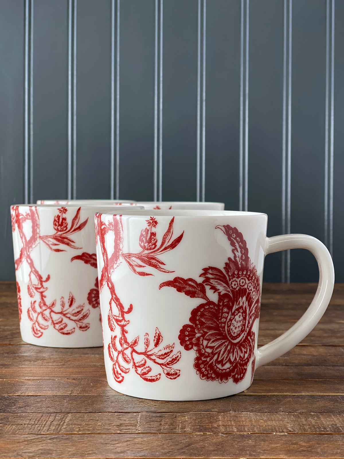 Front view of Arcadia Mug Crimson showcasing crimson colonial floral pattern with a wood tabletop background