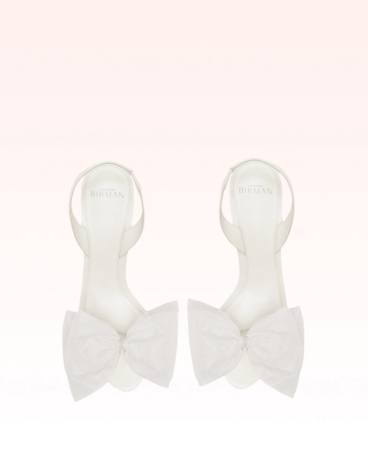 Top view of the Isabelle 85 Bridal Sandal in White showcasing oversized tulle rosettes and slingback straps on a pale pink background