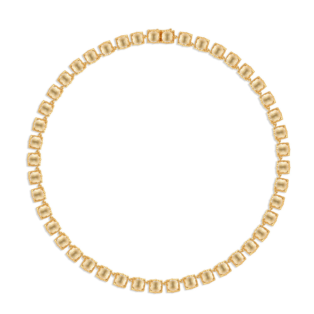 Top-down view of Bella Small Rivière necklace with cushion-cut white quartz in gold collet settings on white background