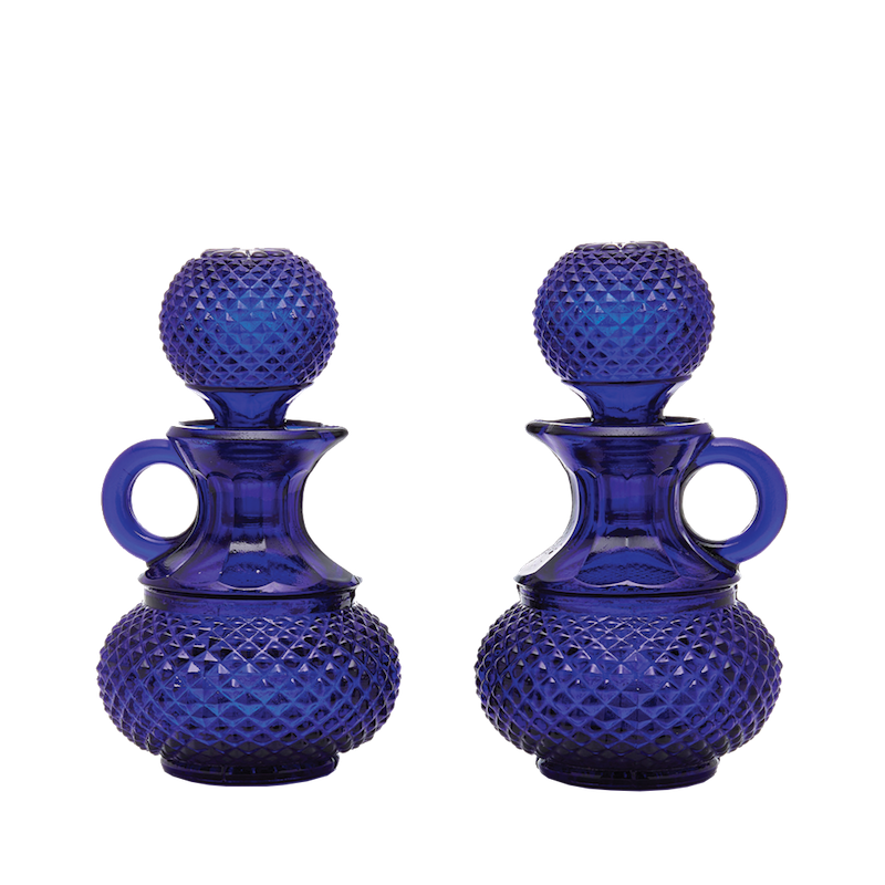 Front view of Galeano oil and vinegar set in cobalt blue glass with hobnail texture, round stoppers, and loop handles