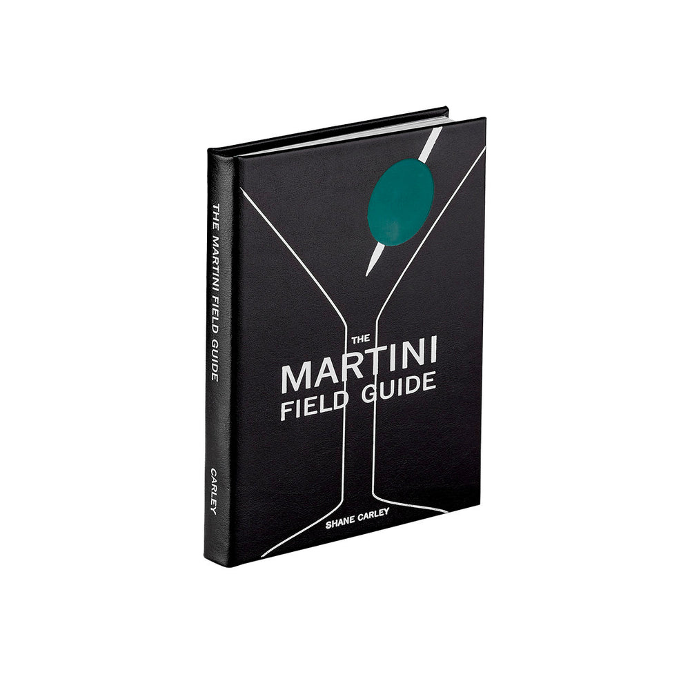 Three-quarter view of The Martini Field Guide in black bonded leather showing martini glass cover with green olive on white