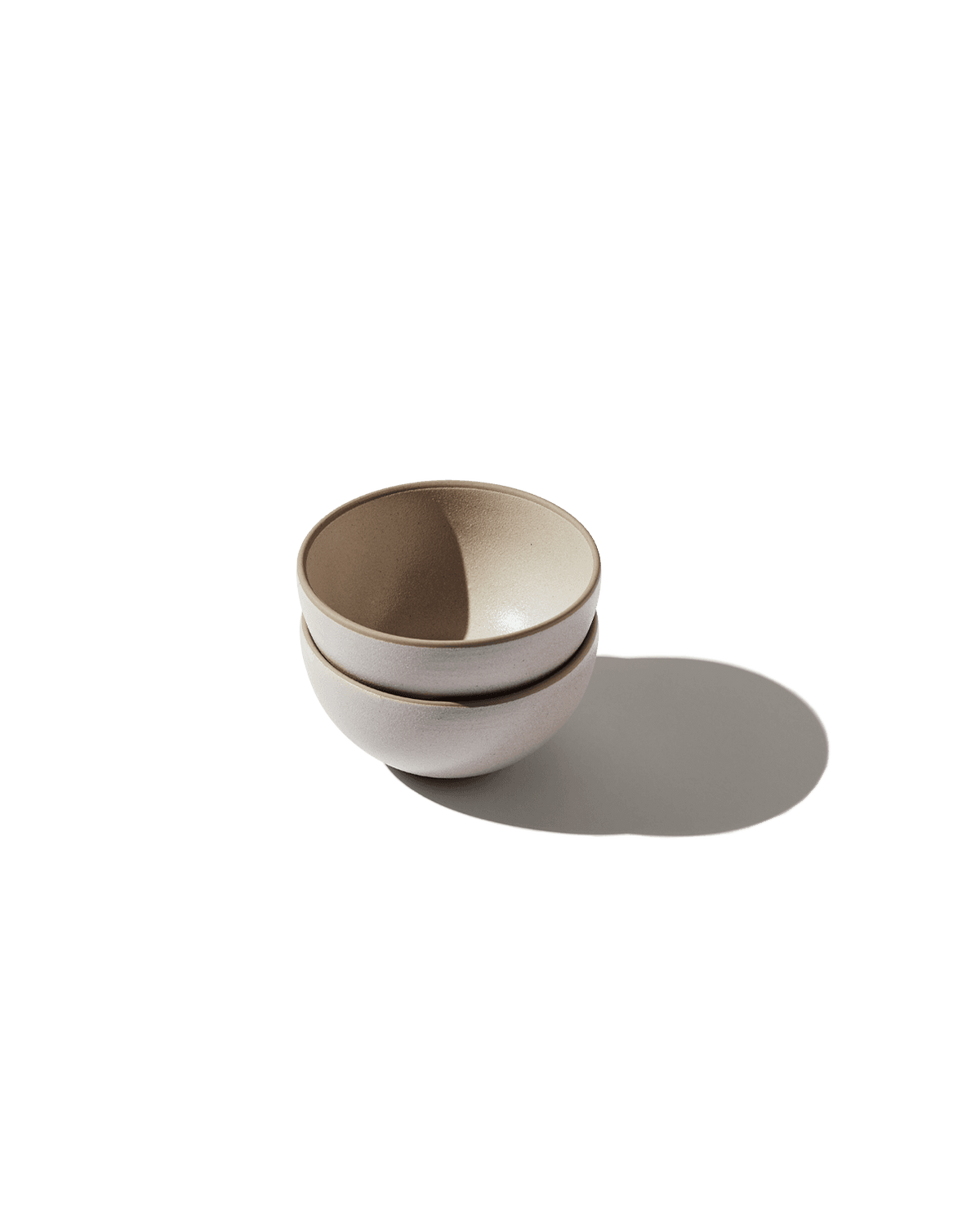 Angled view of The Bap Bowl, Set of 2, showcasing two stacked bowls on a dark green background