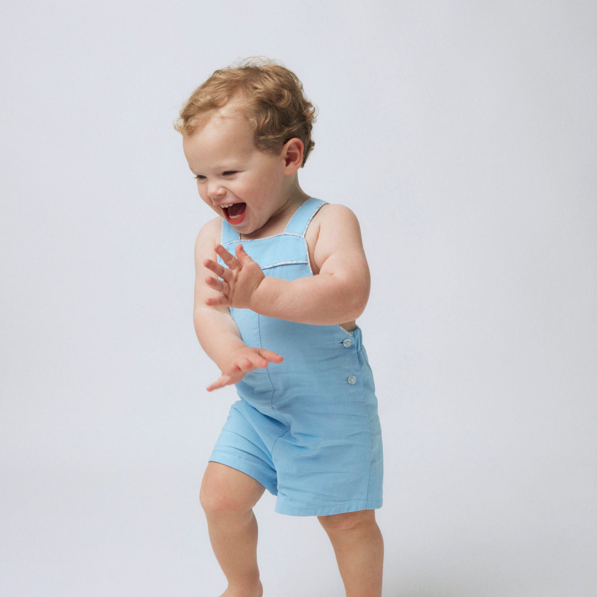 Front view of Boys Peri Blue Overall showcasing adjustable shoulder straps and side buttons on a toddler against a light gray background