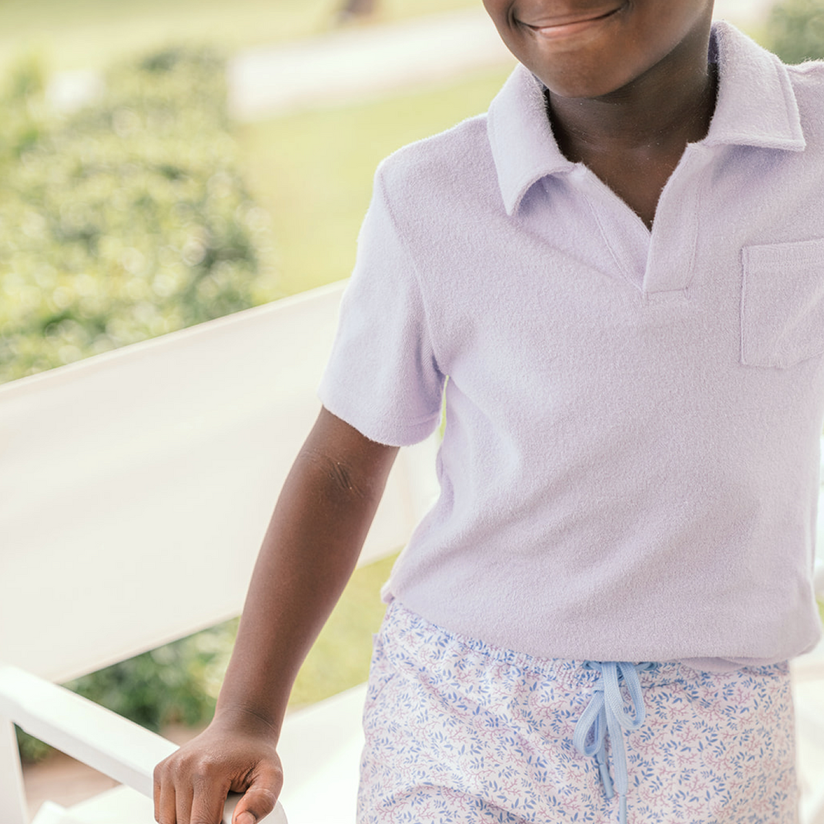 Front view of Boys Bay Lavender French Terry Polo Shirt showcasing classic collar and front pocket worn by a child outdoors