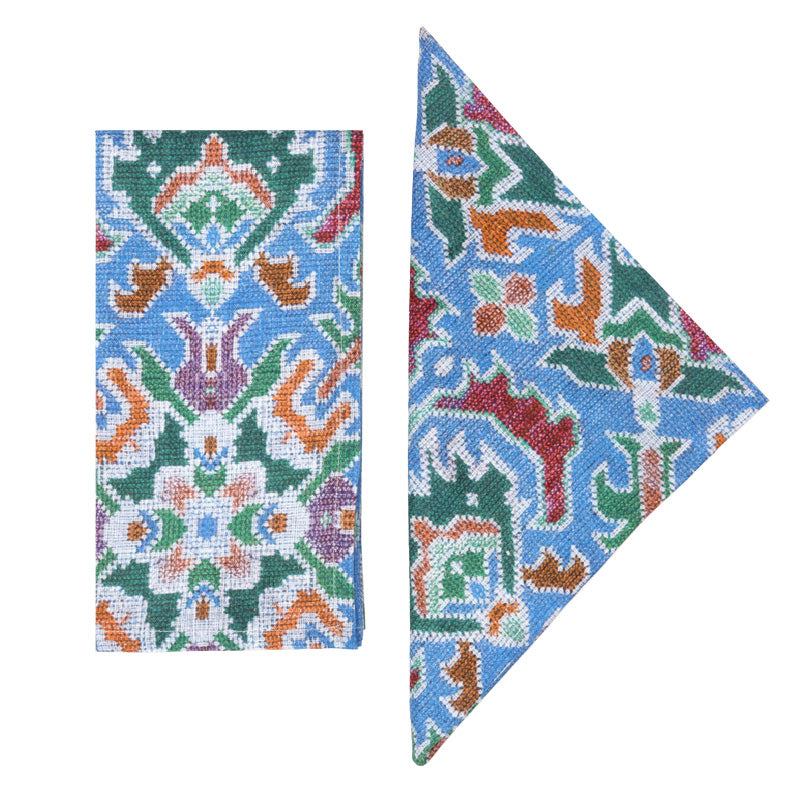 Flat lay of Fiamma Napkins in Blue, Set of 4 showcasing multicolor printed pattern on blue linen against white background
