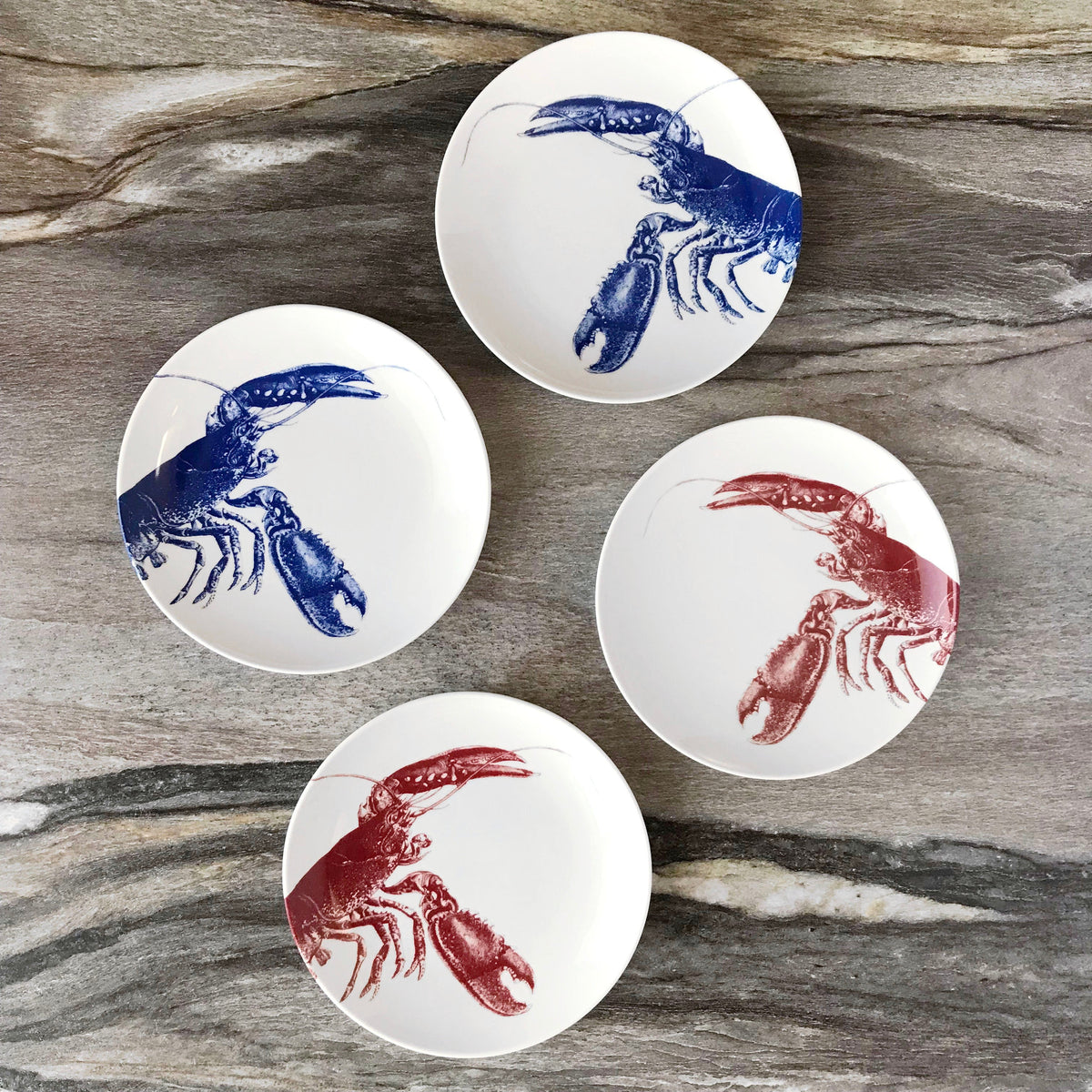 Overhead view of Blue Lobster canapé plates showcasing hand-drawn lobster designs on a wood table
