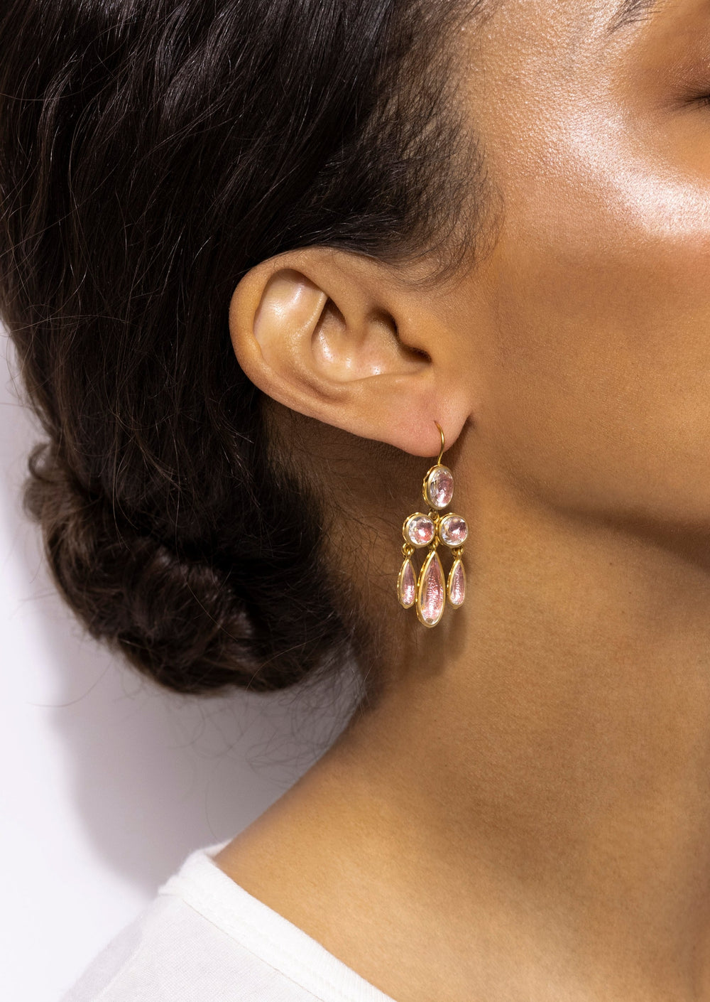 Side view of Catherine Girandole earrings in blush with three pear-shaped blush-foiled quartz stones and 18k gold-wash earwire on a model
