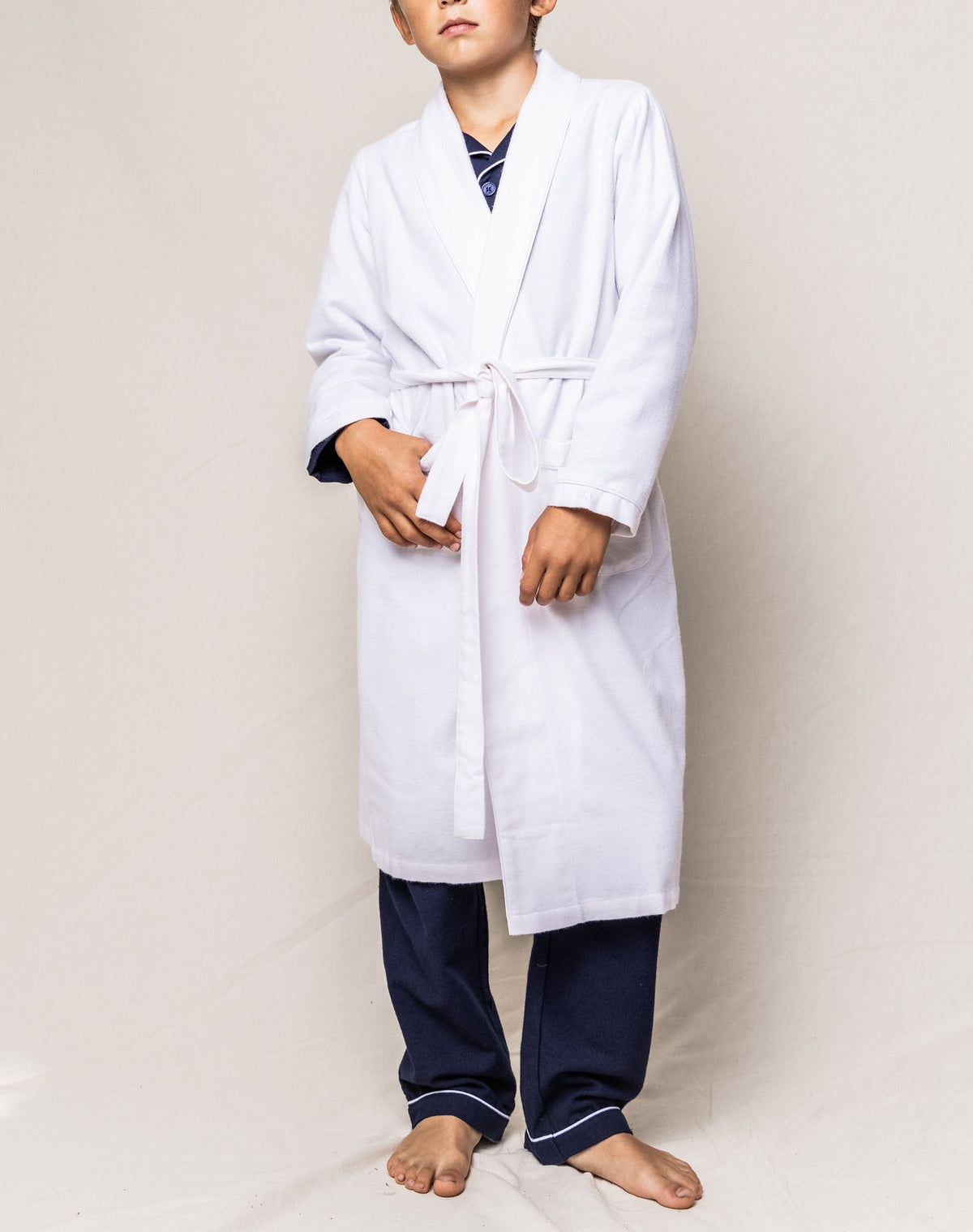 Front view of White Flannel Robe showcasing shawl collar, tie waist, long sleeves, and patch pockets on a model against a light background