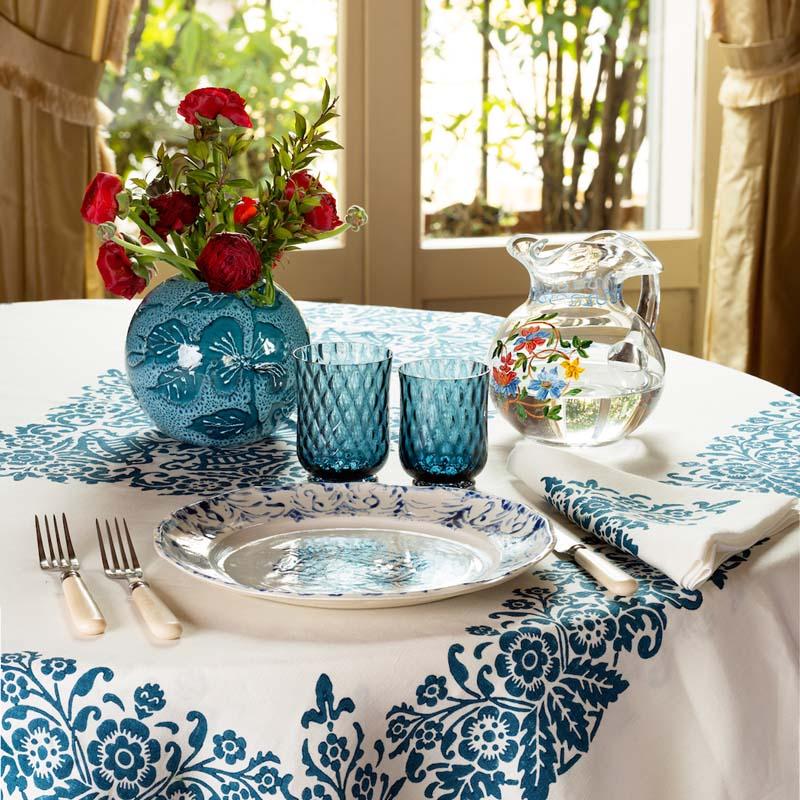 Murano hand-painted jug displayed on a floral dining table with blue glassware and flowers
